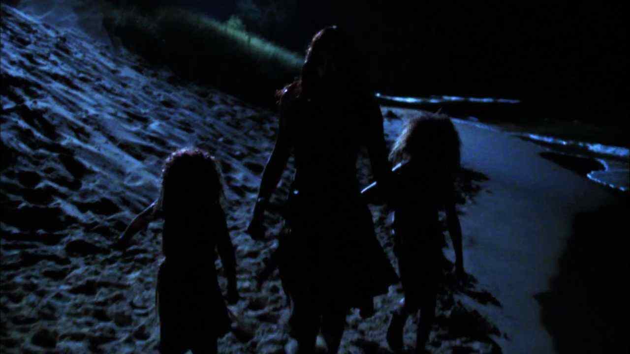 The cannibal family walks on the beach back to their cave in Offspring. The Woman